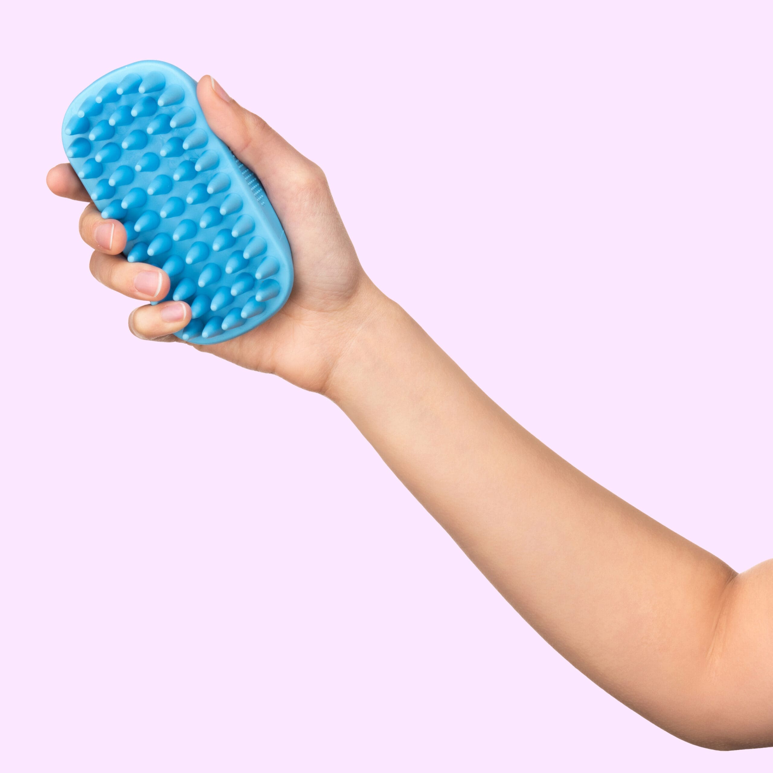 Hand model photo showing a hand holding a silicone pet fur brush.